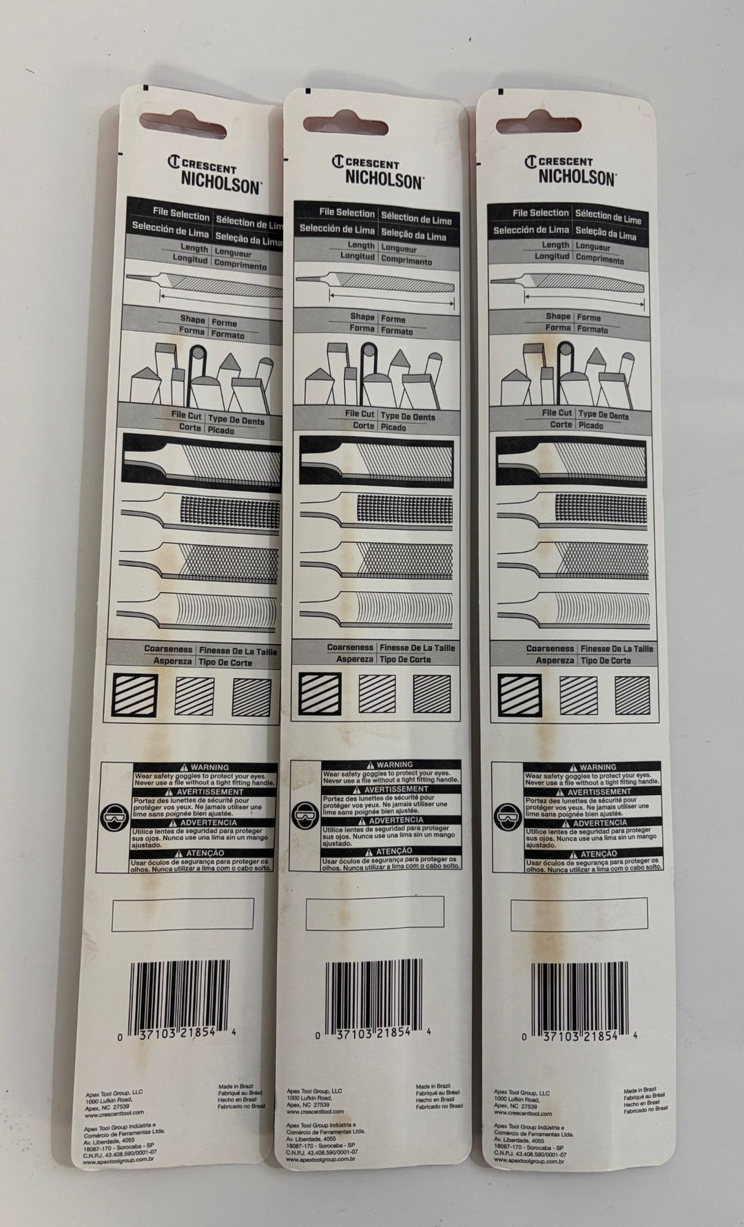 Packaging backs of three Apex Tool Group Crescent Nicholson round files displayed side by side, showing file shape, cut type, and coarseness selection charts with safety warnings and barcodes.