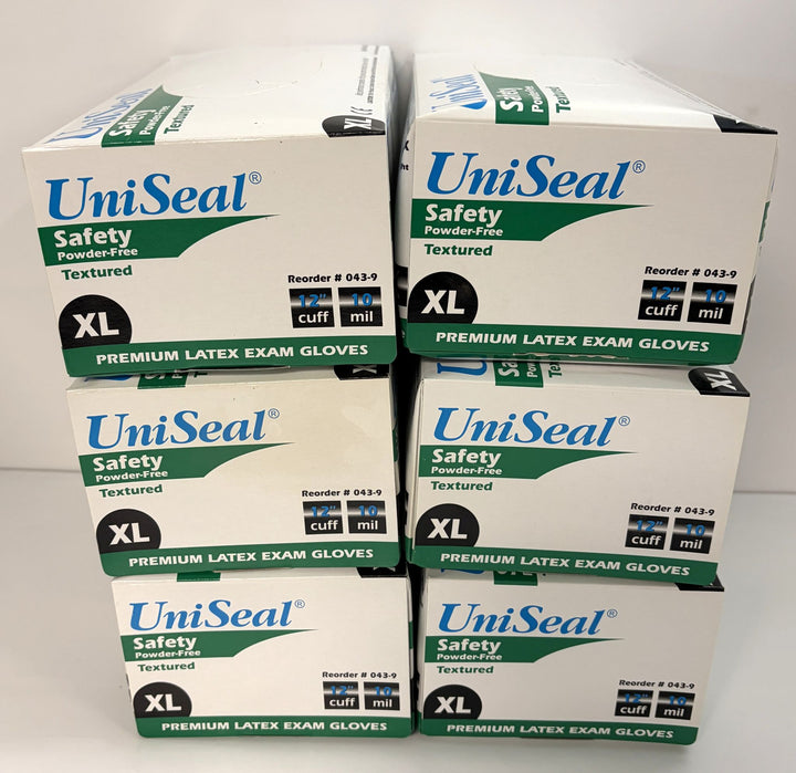Stack of six white and green UniSeal boxes containing extra-large powder-free latex exam gloves with textured surface and extended cuff for safety and durability.