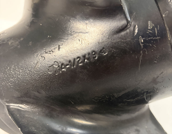 Close-up of a black metal component from a Volvo marine propeller showing stamped serial or part numbers with visible wear and texture.