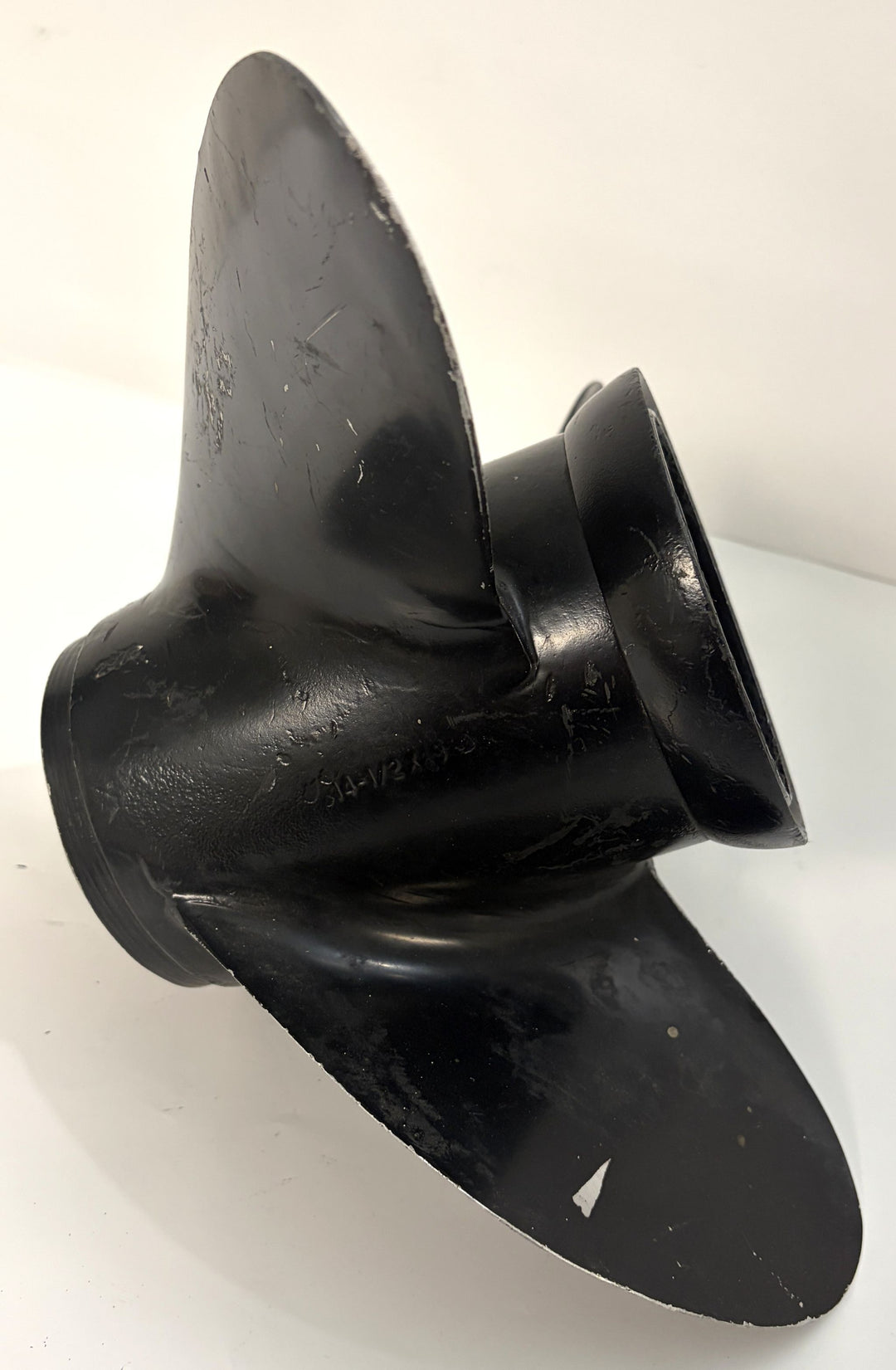 Black aluminum marine propeller with three blades, showing surface wear and a 19-spline hub, photographed against a plain white background.