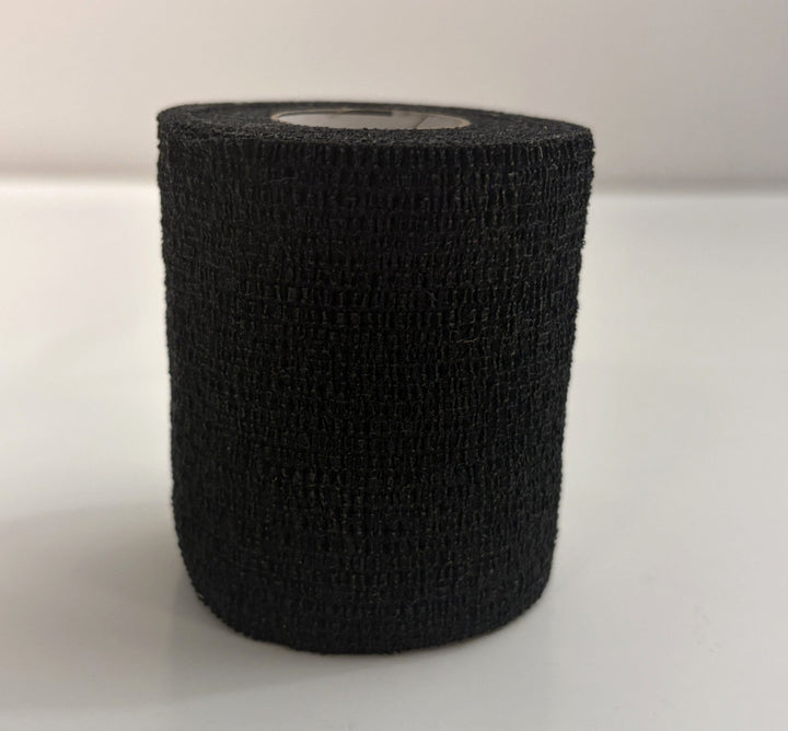 Roll of black self-adhering sports wrap made by Milliken, shown upright on a white surface with textured fabric for athletic support and compression use.