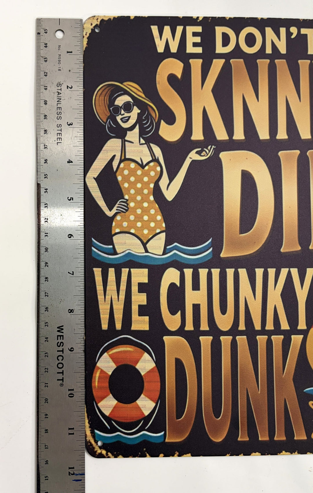Metal novelty pool sign with a vintage-style woman in a polka dot swimsuit and humorous text about chunky dunking, measuring approximately 8 by 12 inches.