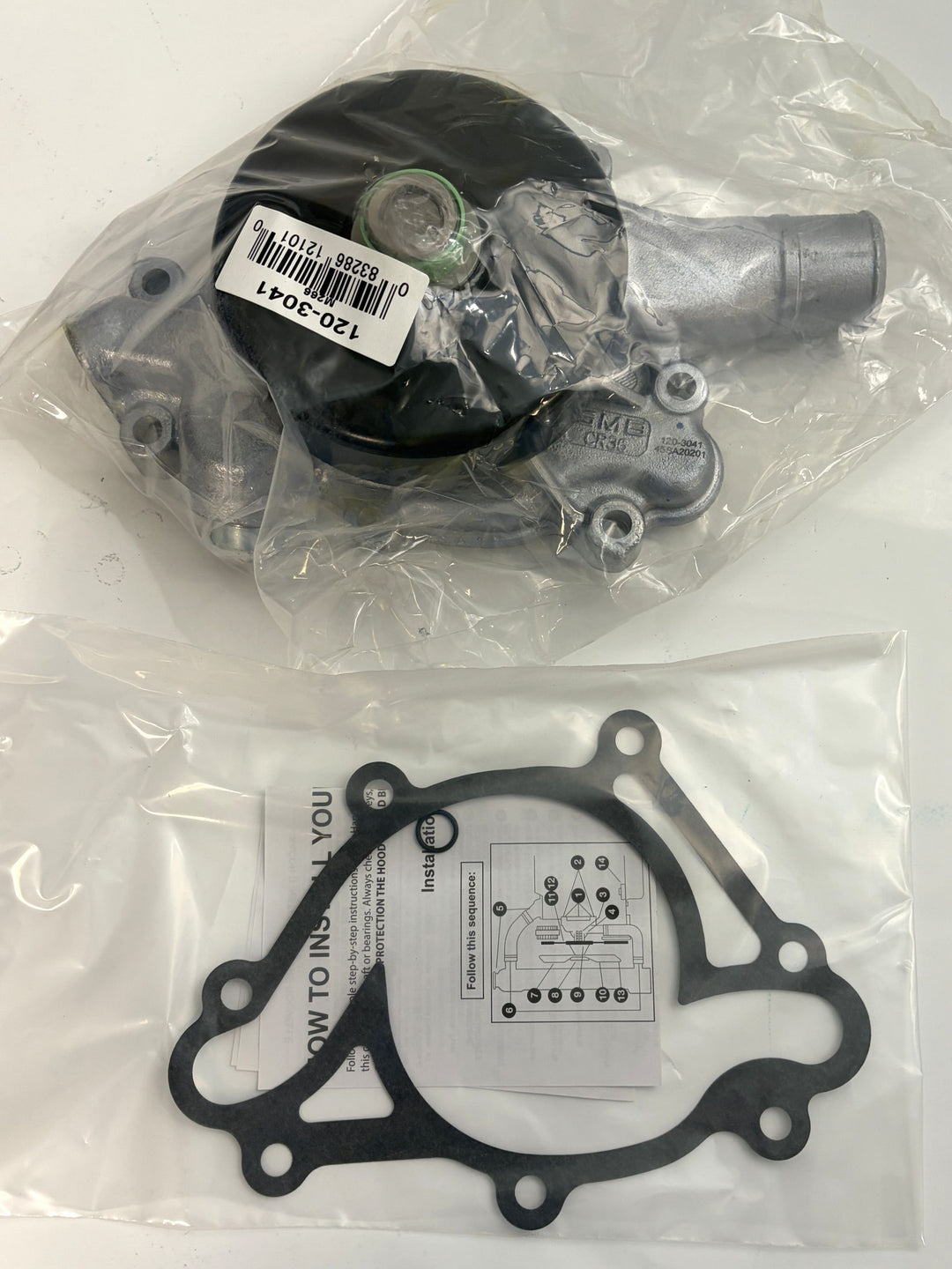 NAPA engine water pump with attached gasket and installation instructions, packaged in clear plastic, suitable for automotive cooling system repair.