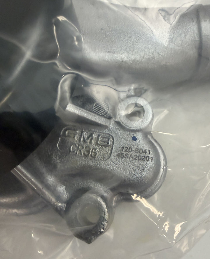Close-up of a NAPA branded engine water pump component made of cast aluminum, sealed in clear plastic packaging, showing part numbers and manufacturing codes.