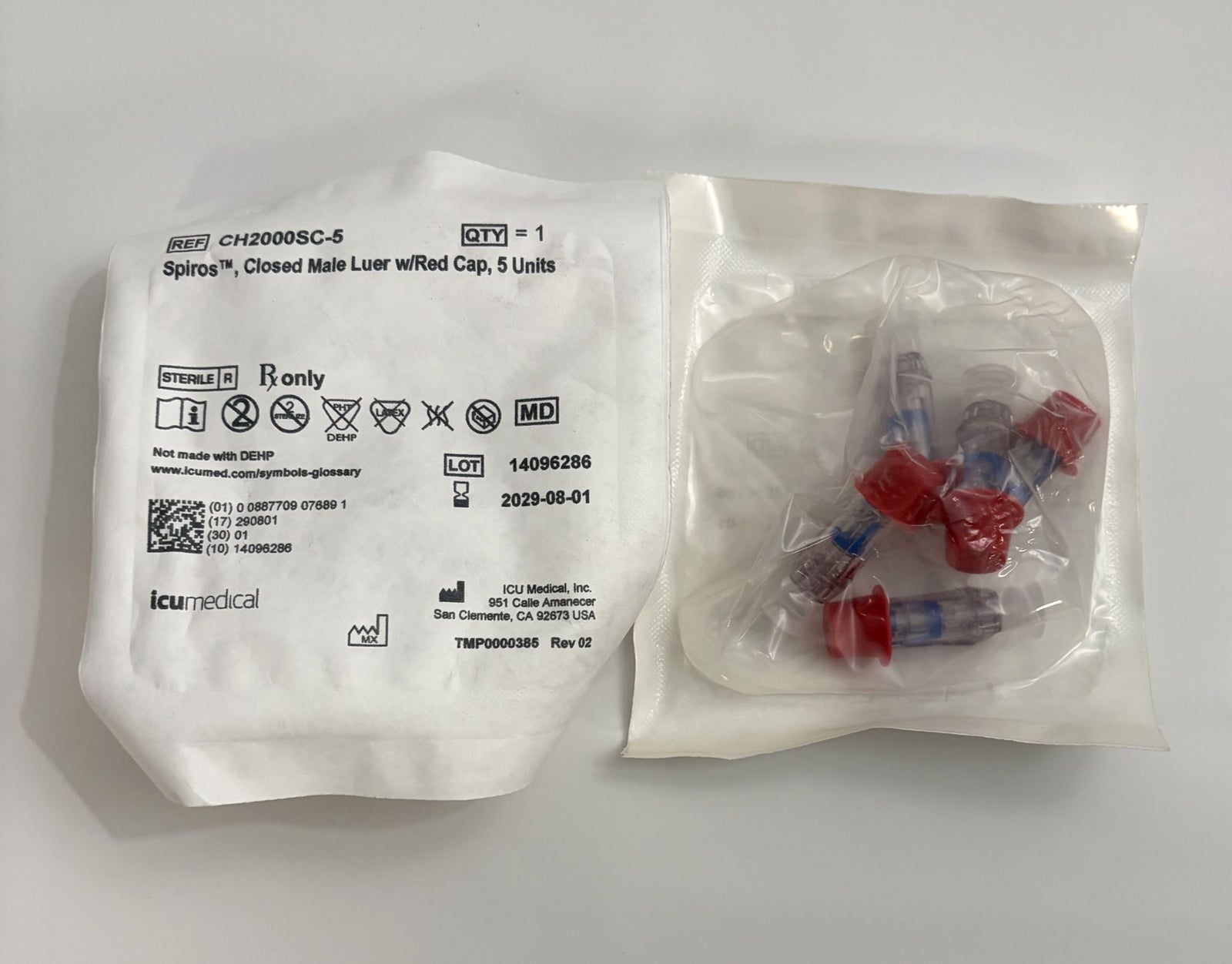 ICU Medical Spiros Closed Male Luer connectors with red caps, packaged in sealed sterile bags for safe medical use, shown with one unopened and one opened pack.