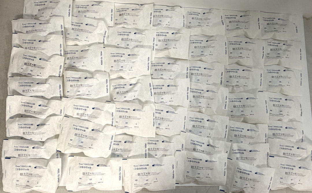 Multiple individually packaged ICU Medical ChemoLock CL-13 bag spikes with additive port, arranged in rows on a flat surface, new and sterile medical supplies for clinical use.