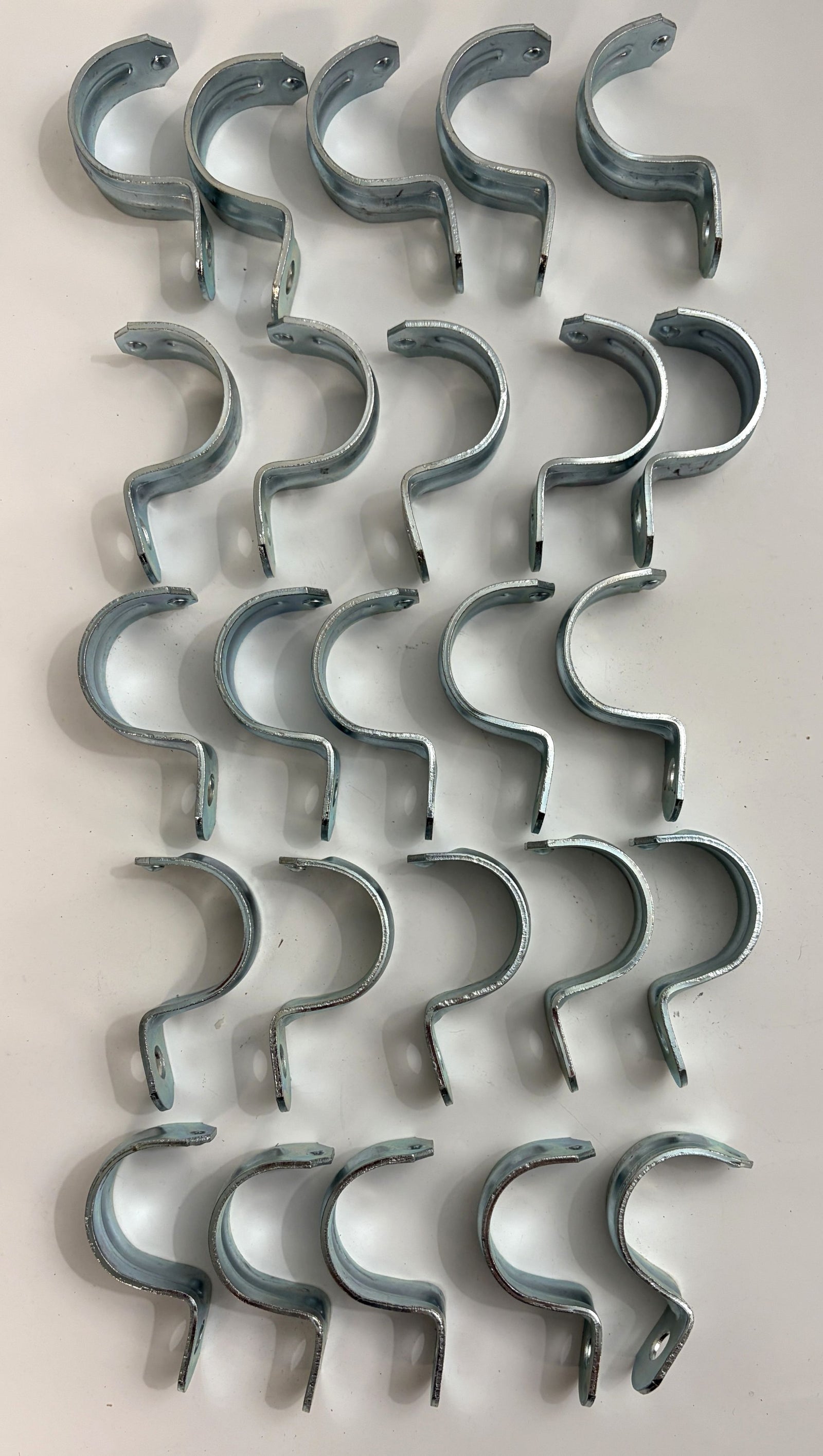 Arlington steel one hole EMT conduit straps arranged in rows for securing one and one quarter inch electrical conduit 25 pack