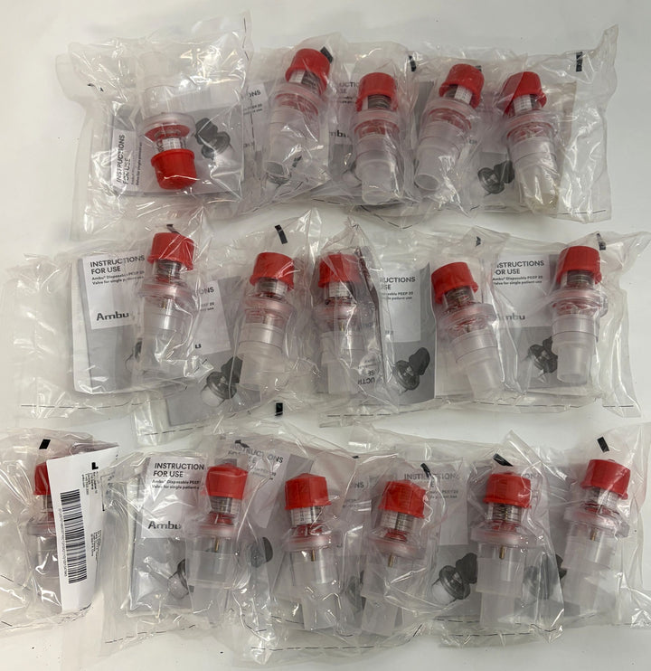 Multiple individually packaged Ambu medical respiratory devices with clear plastic bodies and red caps, arranged on a white surface