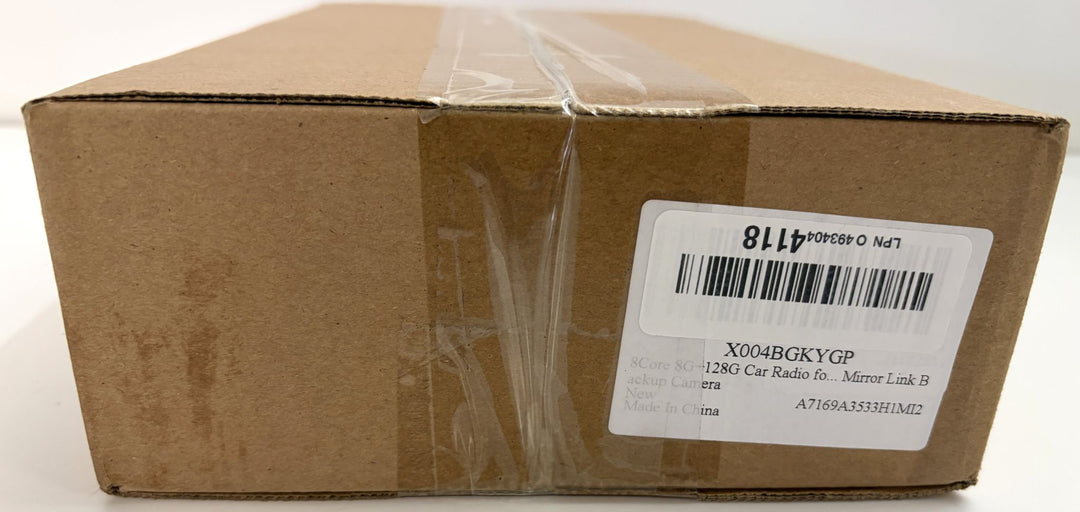 Sealed brown cardboard box with clear packing tape and a white barcode label bearing printed alphanumeric codes.