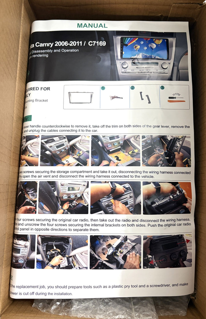 Printed manual labeled Camry 2006-2011 and C7169, showing car stereo removal instructions and installation photographs inside a cardboard box.