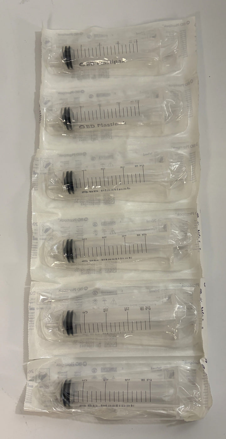 BD 20 mL Luer syringes individually sealed in clear plastic medical packaging, arranged in a stacked strip with graduated measurement markings