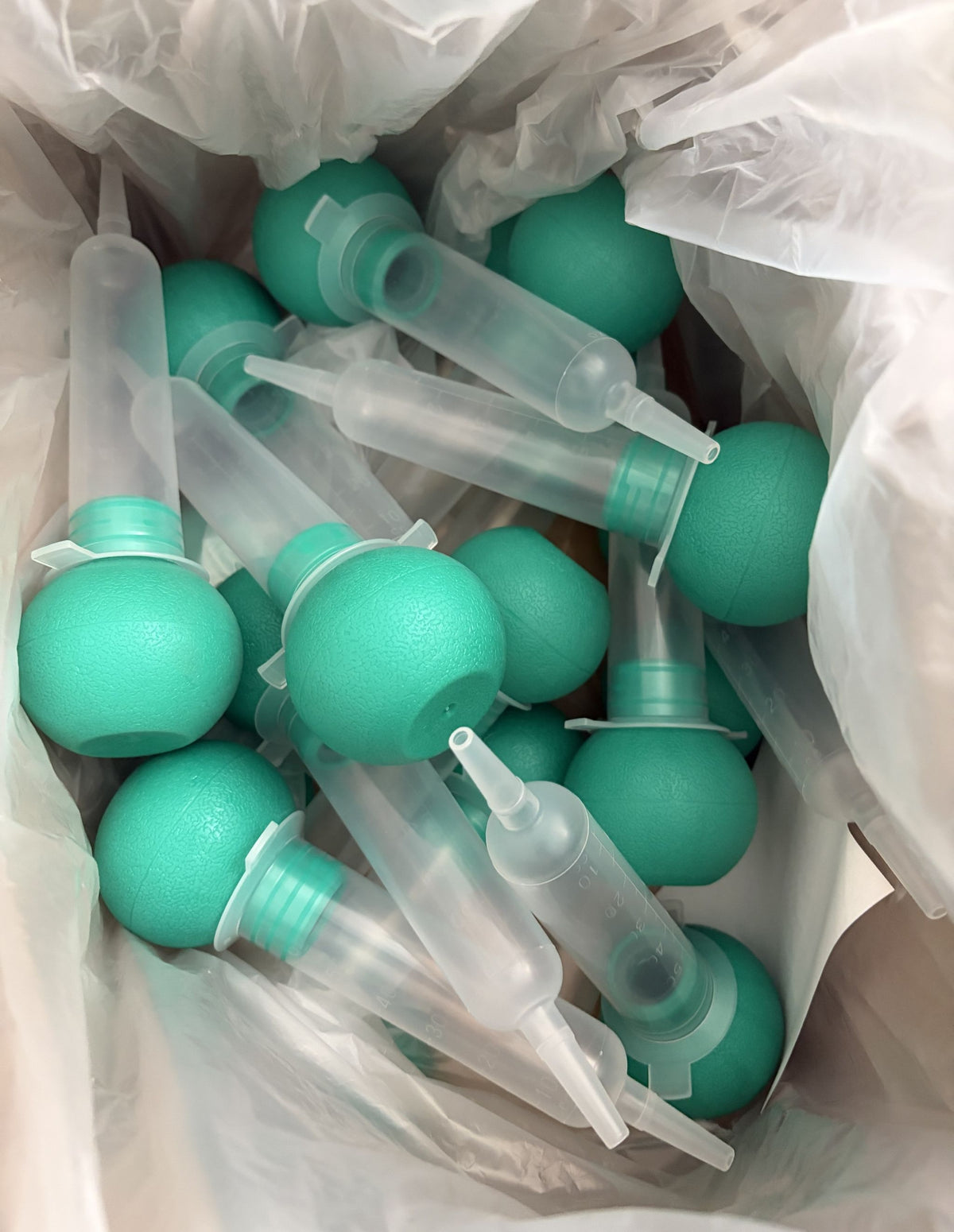 Amsino AmSure AS010 60mL bulb irrigation syringes with teal bulbs and translucent latex-free barrels shown together in medical packaging