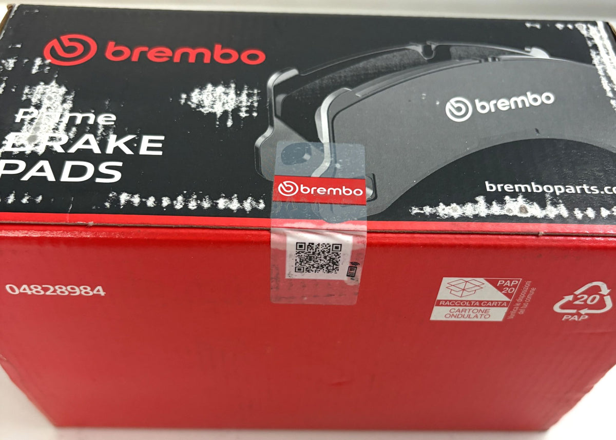 Brembo P85144 Prime low metallic front brake pad set in red and black packaging with QR seal and visibly scuffed, worn surfaces