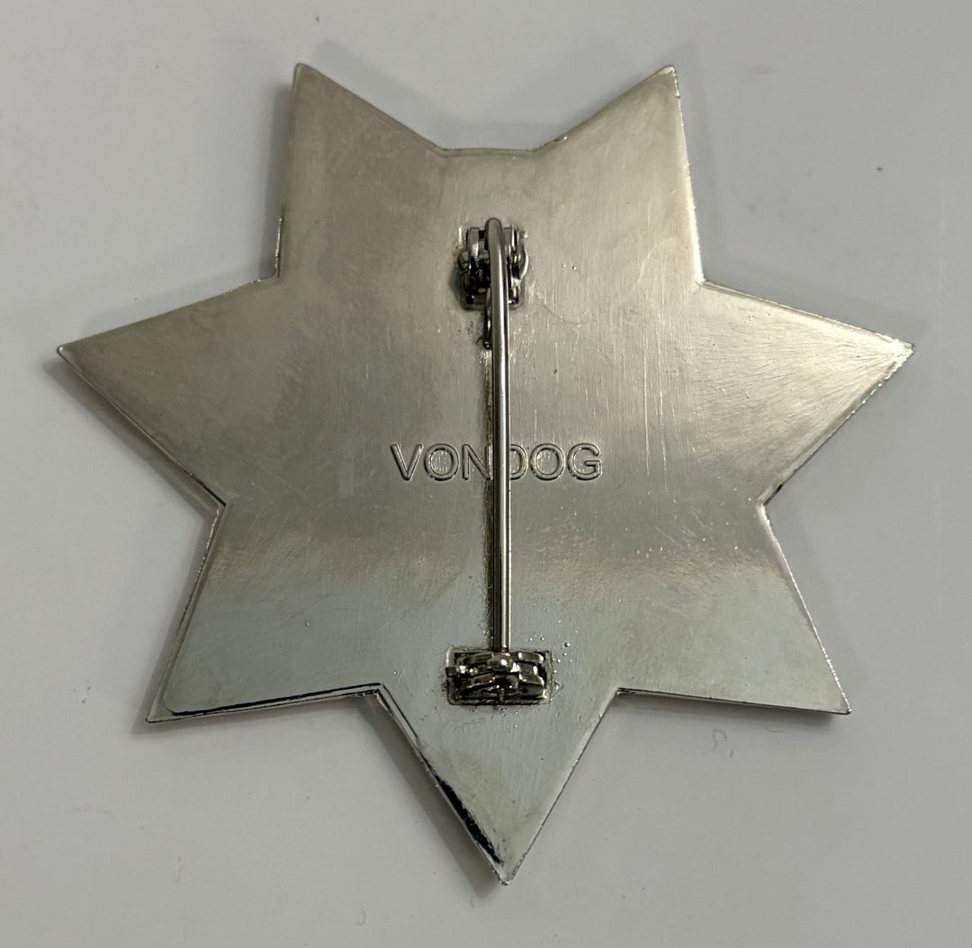 Silver star-shaped brooch with 'VONDOG' branding on a light gray background