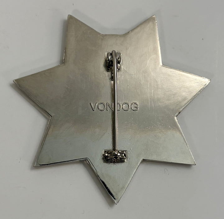 Silver star-shaped brooch with 'VONDOG' branding on a light gray background