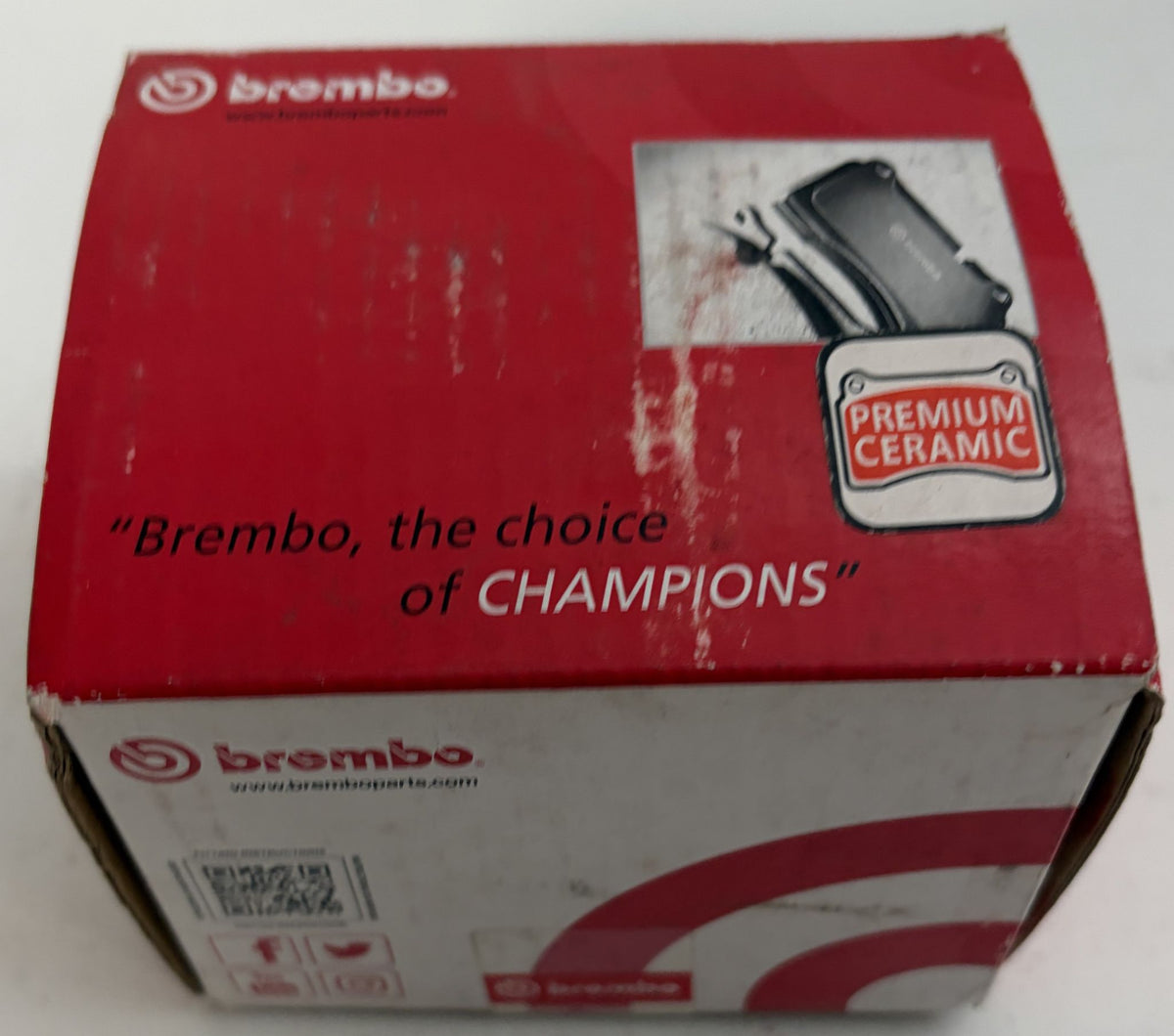 Brembo Premium Ceramic rear brake pad box for automotive use, featuring red and white packaging with brake pad artwork and branded graphics