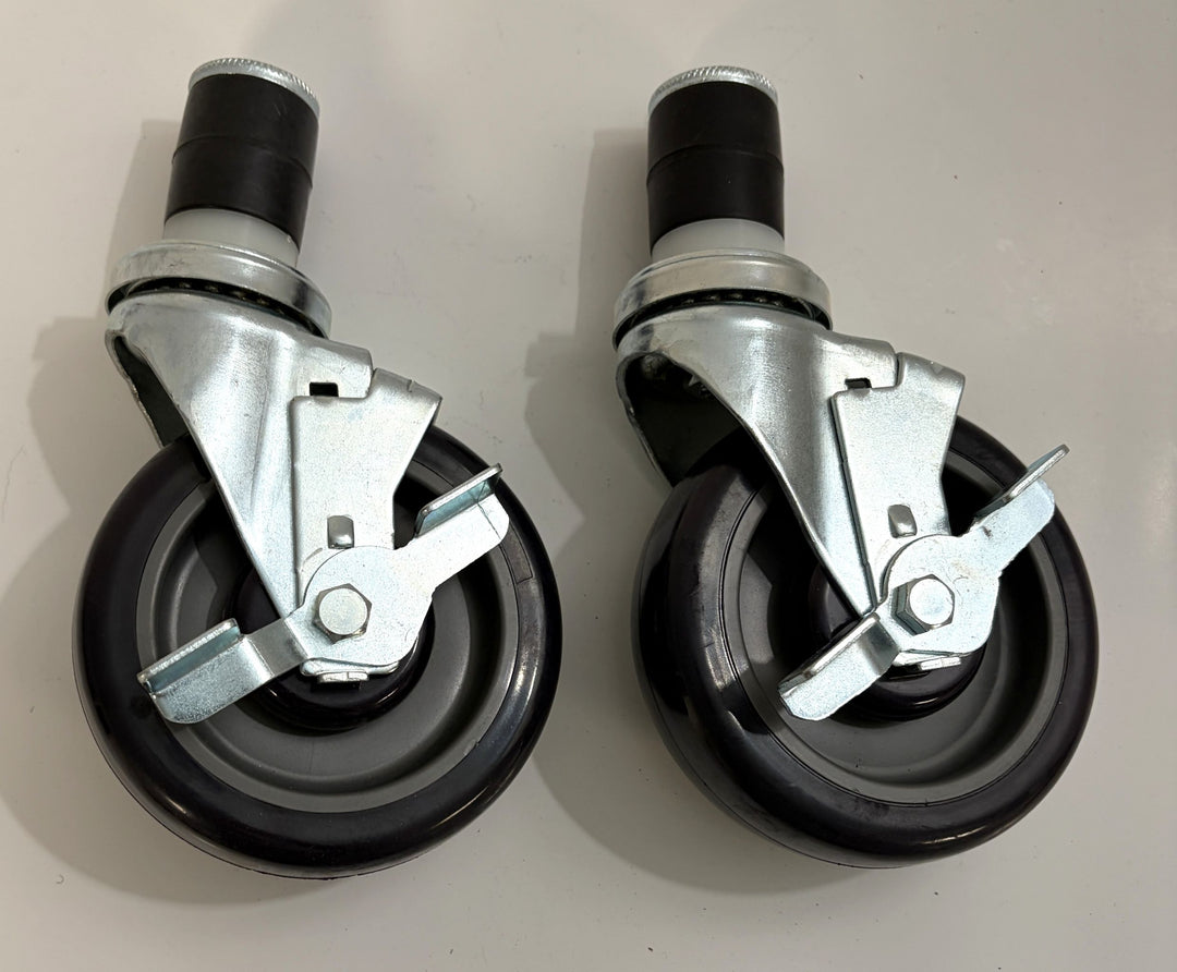 Two black caster wheels with metal brake mechanisms on a light gray background