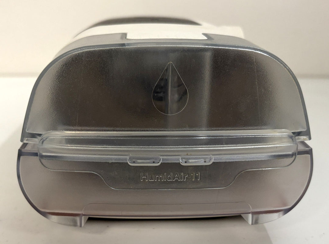 Resmed AirSense 11 HumidAir water chamber for pre-owned CPAP medical equipment, shown from the front with a translucent gray finish