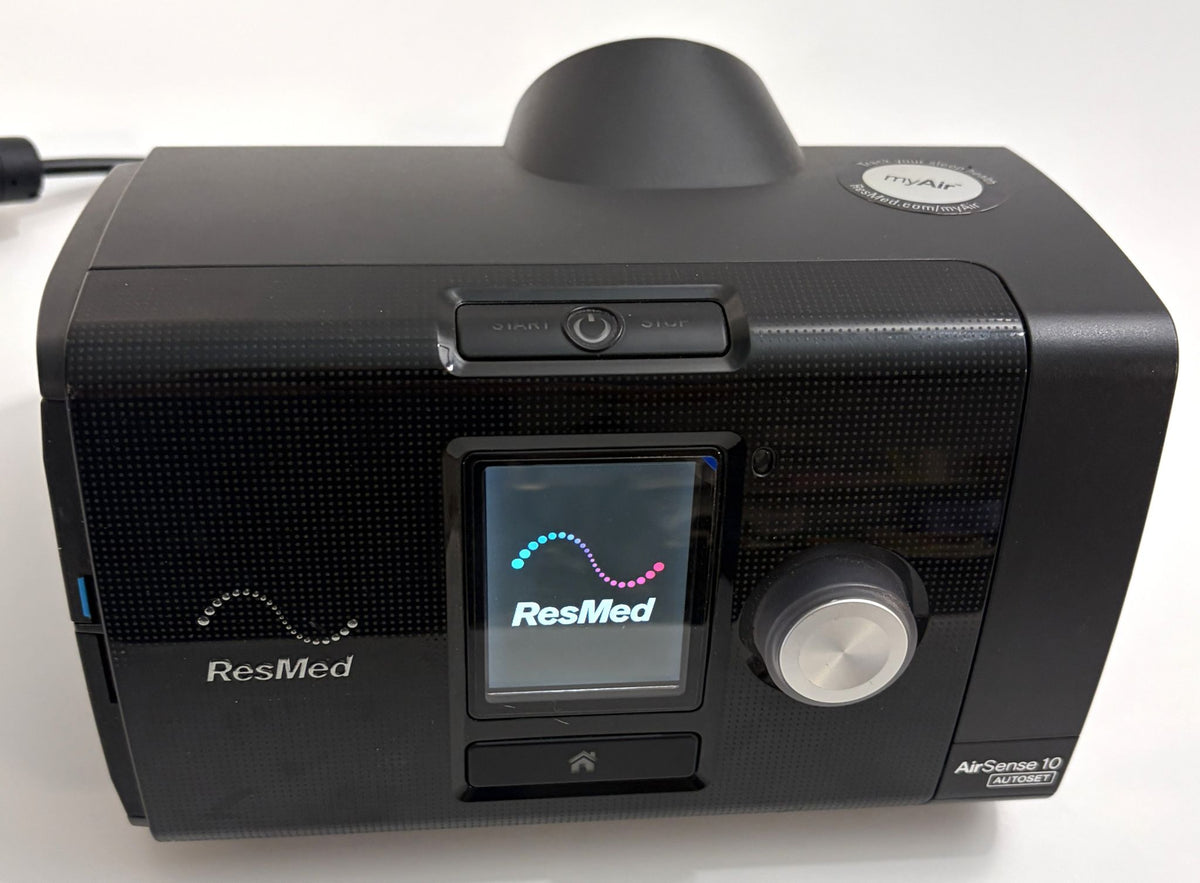 ResMed AirSense 10 AutoSet CPAP console in black with illuminated display, control dial, power button, and pre-owned condition visible