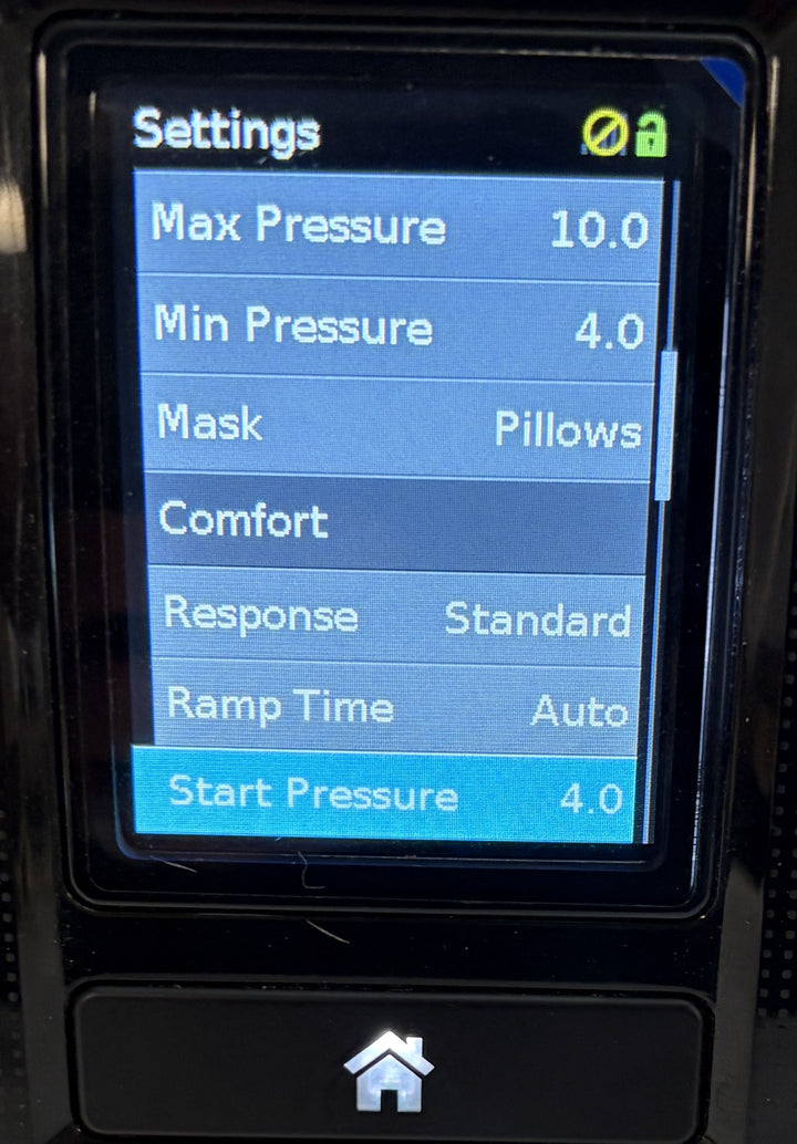 Resmed AirSense 10 AutoSet CPAP console displaying pressure, pillows mask, comfort, response, ramp time, and start pressure settings on its screen