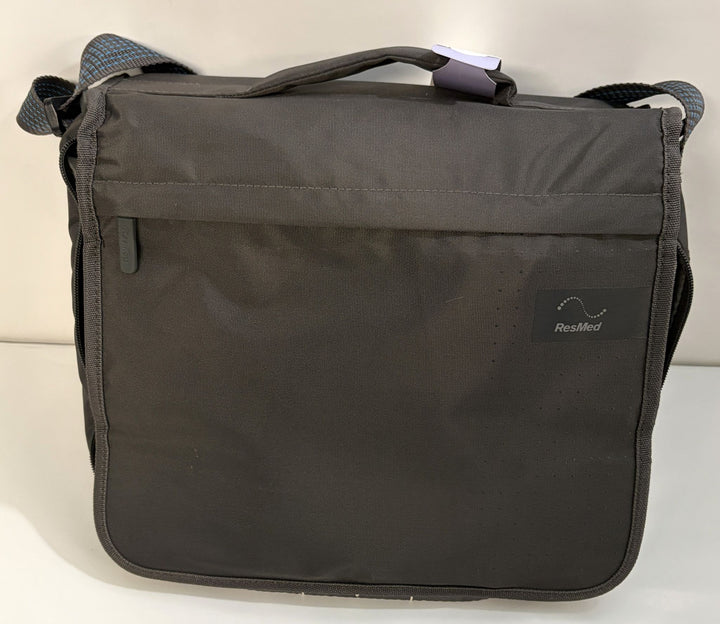 Black ResMed shoulder carrying bag with adjustable strap, front flap pocket, handle, and subtle textured fabric finish.