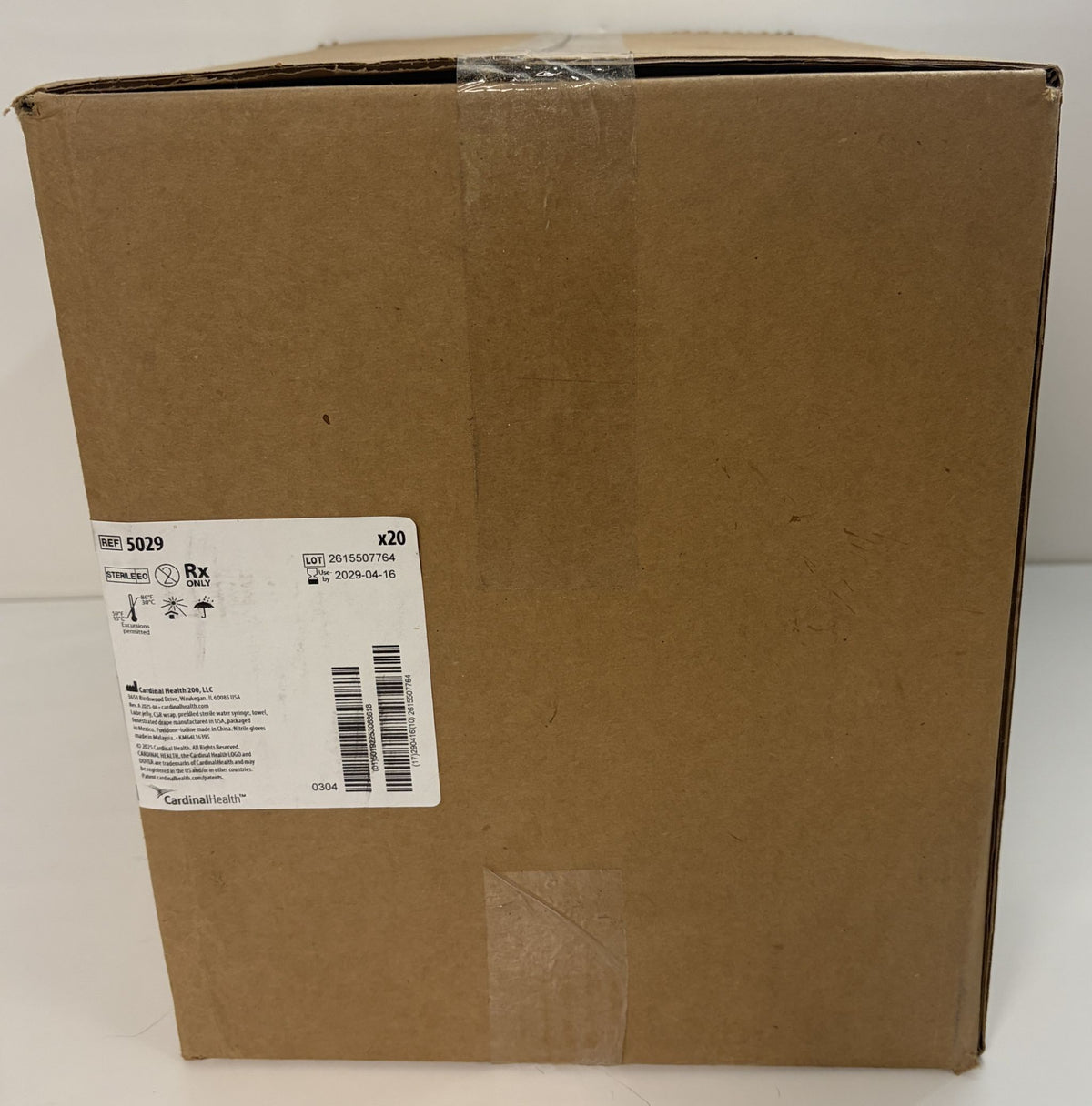 Sealed brown corrugated cardboard carton with a Cardinal Health medical shipping label, Rx symbol, barcodes, and printed reference 5029.