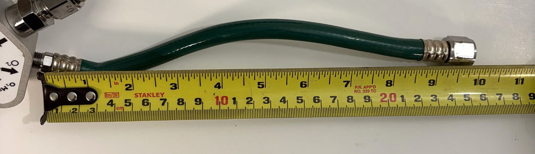 Philips Respironics O2 manifold assembly 1109668 Rev C with green oxygen hose and metal fittings shown beside a measuring tape for scale