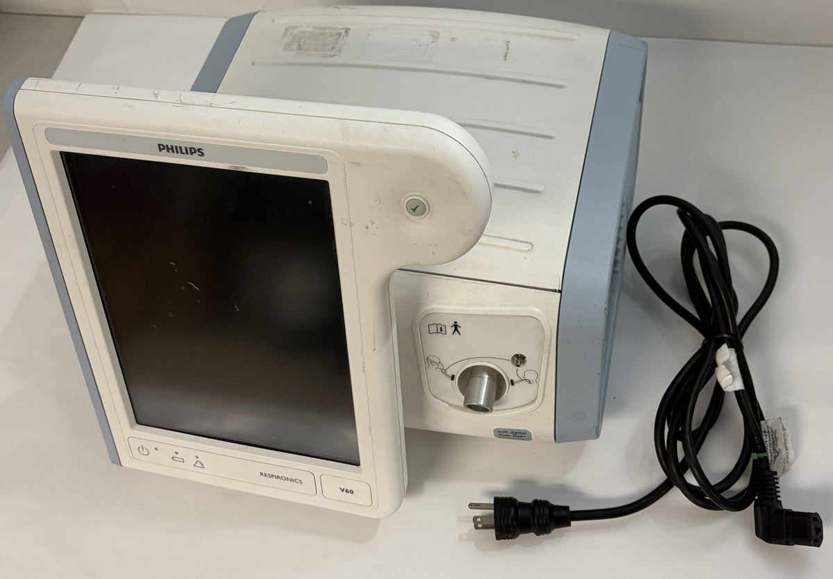 Philips medical patient monitor with blank screen, white housing, control panel, and attached black power cord on a light surface