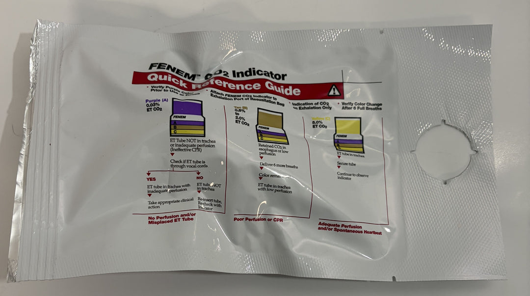 Single-use sealed Fenem CO2 colorimetric indicator packet by Curaplex, showing printed quick reference guide for interpreting carbon dioxide detection results in a medical setting.