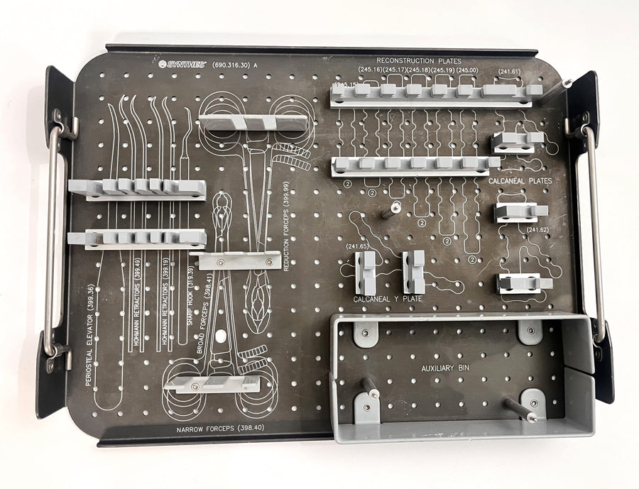 Stainless steel Synthes instrument tray with organized compartments for surgical tools, used in orthopedic and trauma procedures.