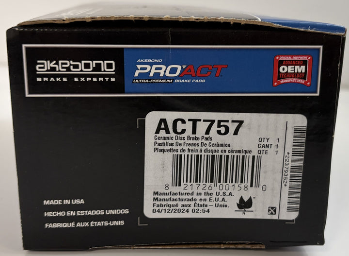 Close-up of a black Akebono PROACT brake pad box showing product label for ACT757 ceramic disc brake pads with barcode and manufacturing details from the USA.