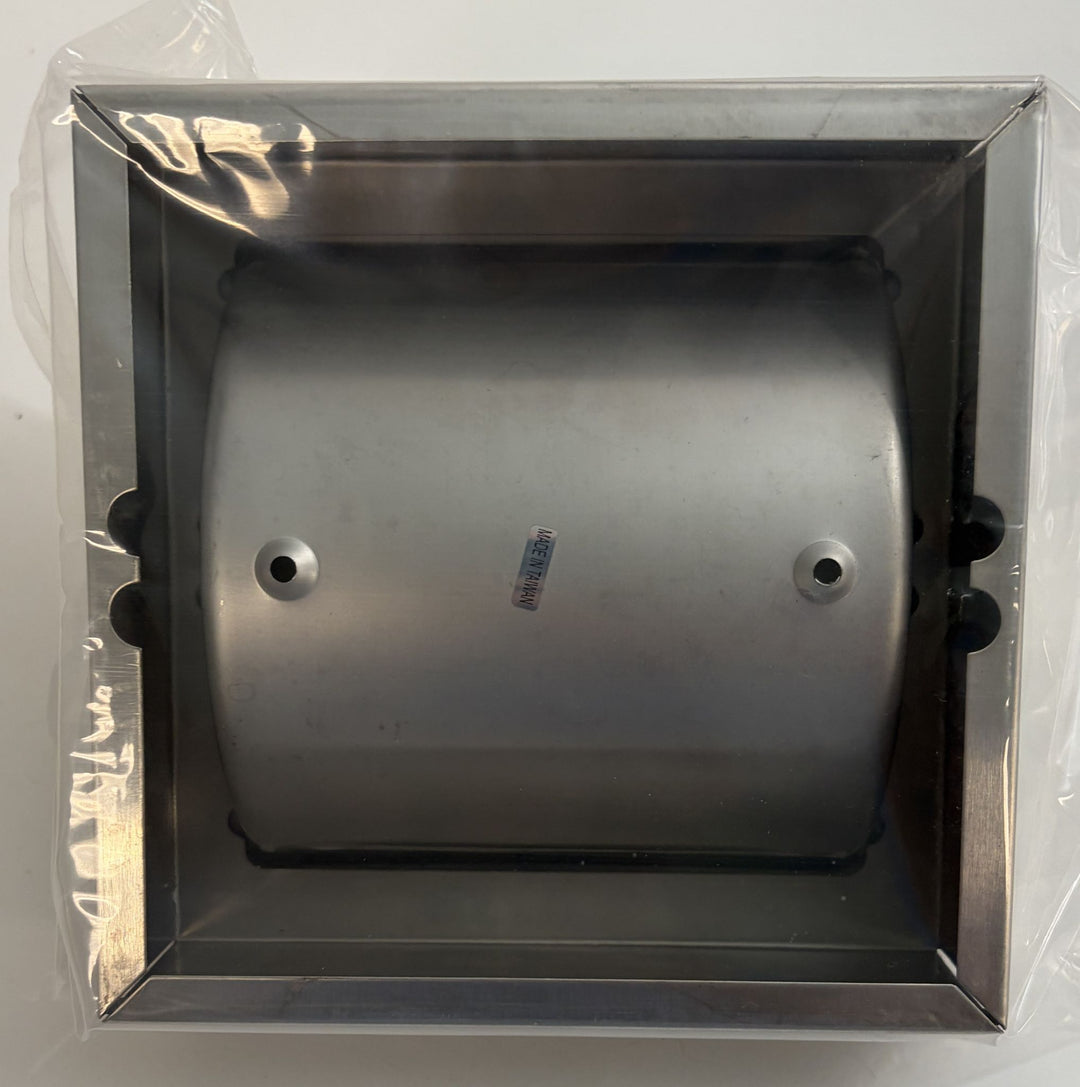 Top view of a satin-finished ASI toilet paper holder with hood and frame, shown inside clear protective packaging against a plain background.