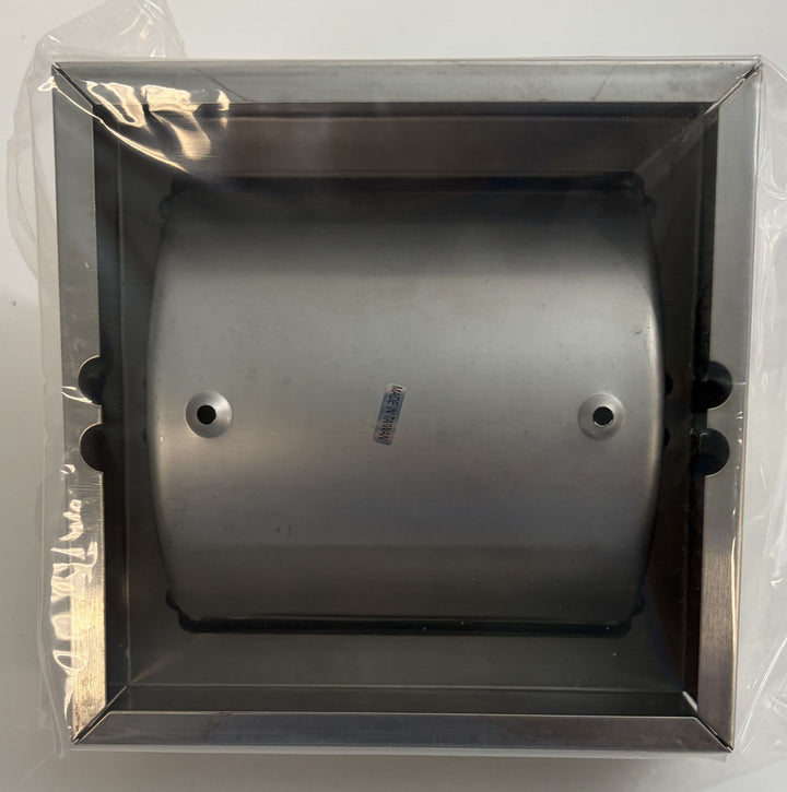 Top view of a satin-finished ASI toilet paper holder with hood and frame, shown inside clear protective packaging against a plain background.