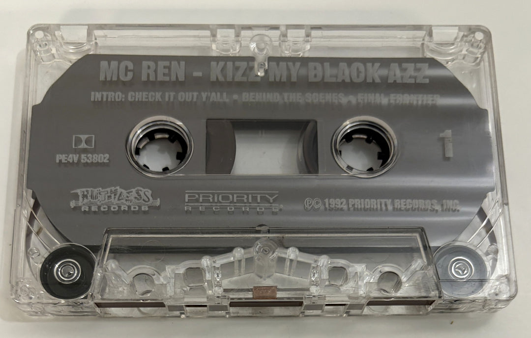 Close-up view of a vintage MC Ren audio cassette tape with clear plastic casing and gray label, featuring Priority Records and Ruthless Records branding.