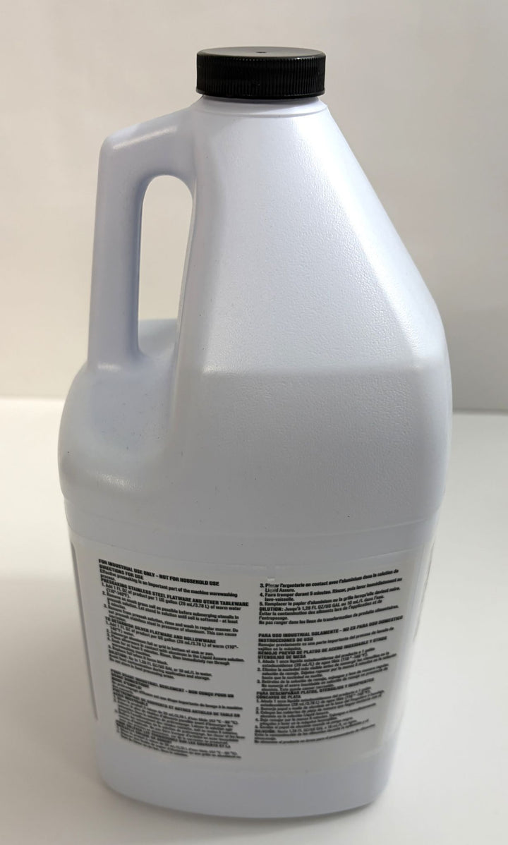 White plastic container with a black screw cap and handle, featuring a multi-language label, containing Ecolab silverware presoaking solution for industrial use.