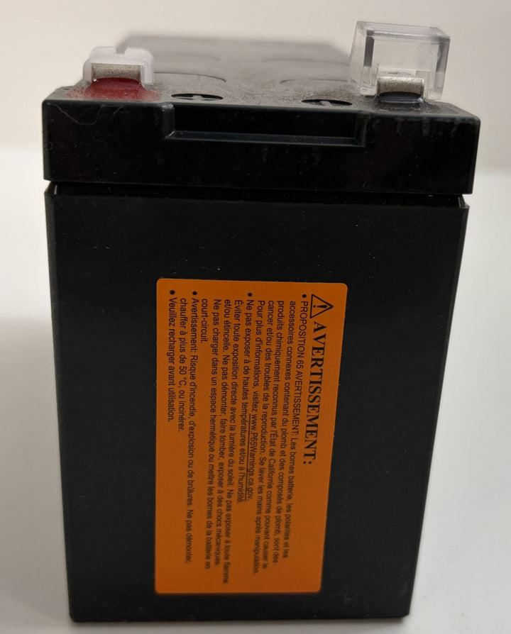 Black battery with an orange warning label on a white background