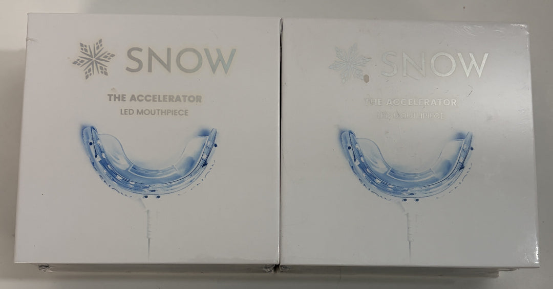 Two Snow branded LED mouthpiece devices for teeth whitening displayed in white retail packaging with blue mouthpiece graphics on a neutral surface.
