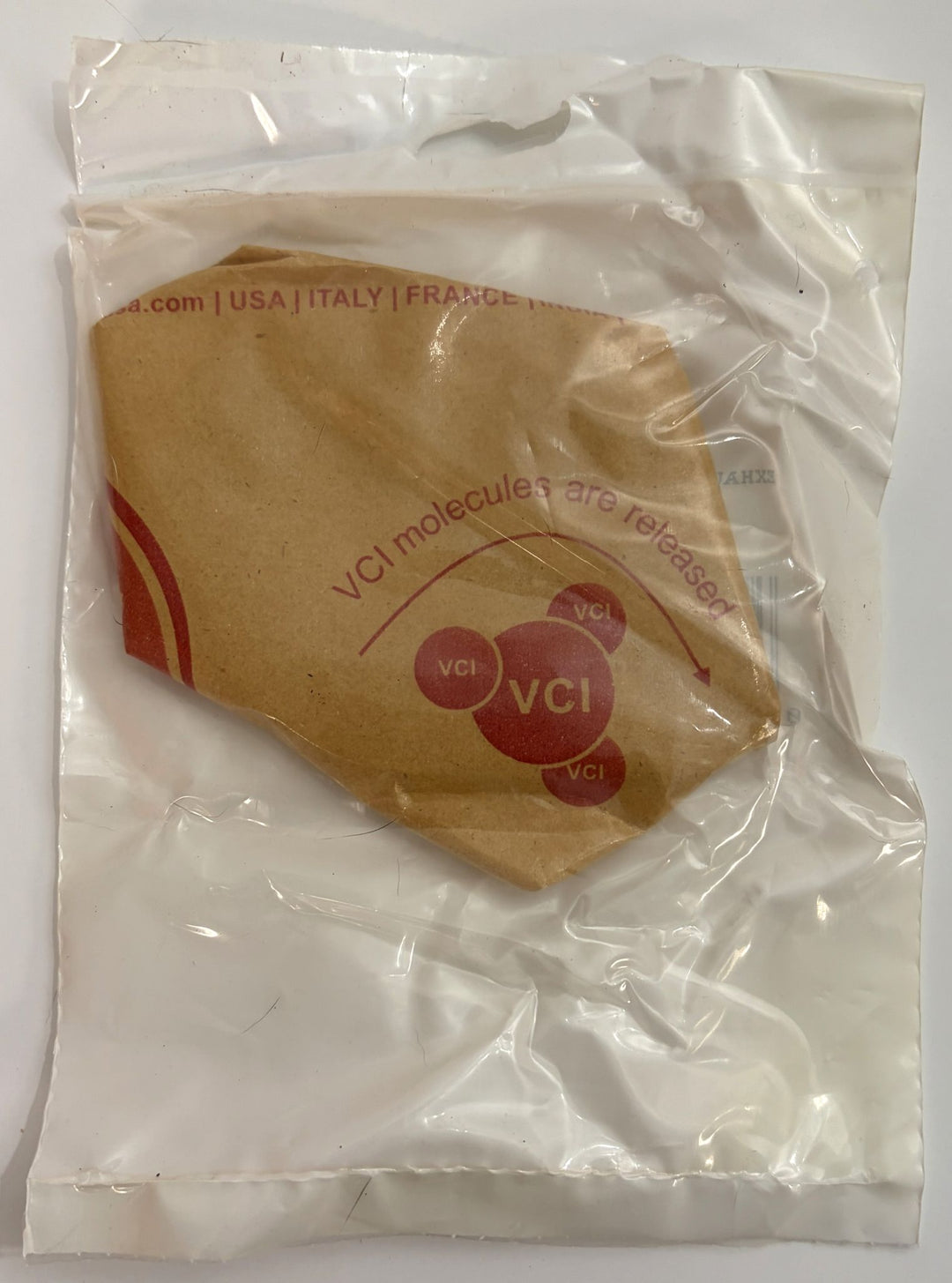 New replacement exhaust pipe flange from Unbranded, sealed in clear protective packaging with printed corrosion inhibitor details visible on brown paper insert.