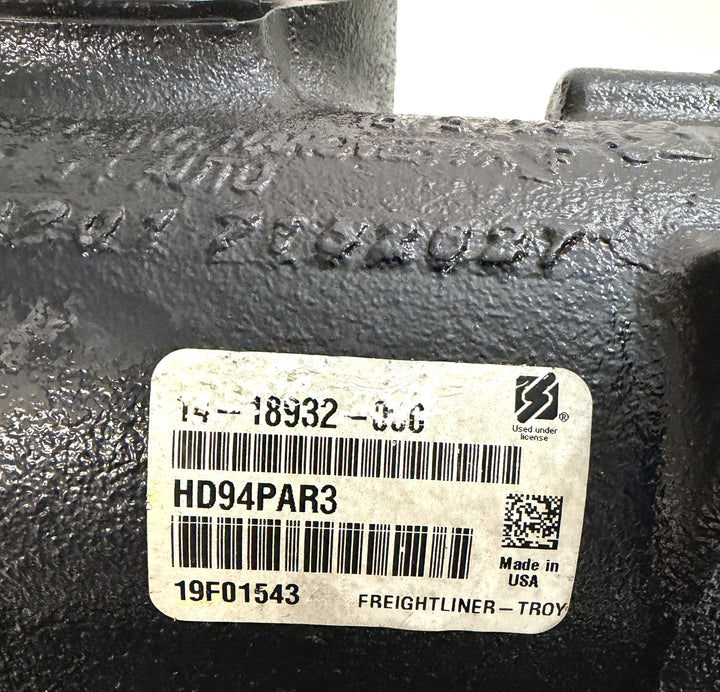 Close-up of a black metal steering gear housing featuring a white barcode label with model number HD94PAR3, made in the USA by Sheppard for Freightliner trucks.