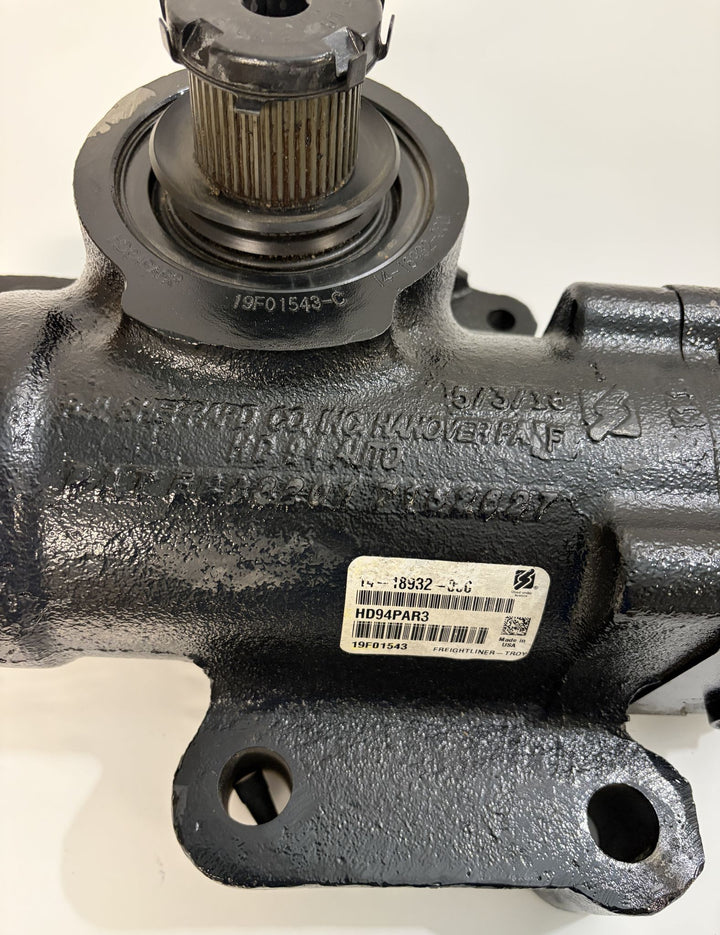 Close-up view of a black metal steering gear component by Sheppard with visible part numbers and a white product label on a plain background.