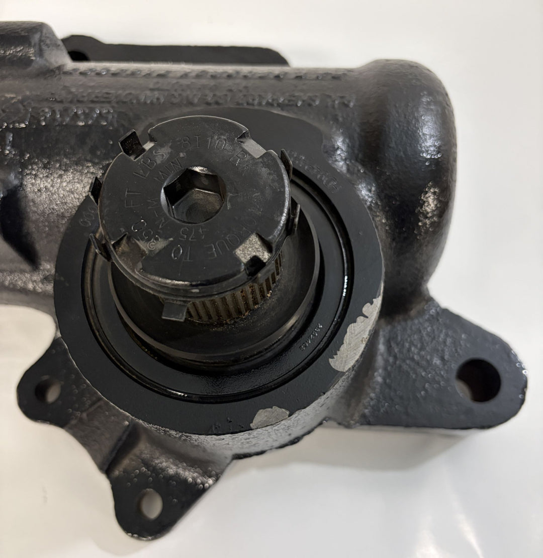 Close-up view of a black cast metal Sheppard steering gear component showing the splined central shaft and mounting points, part of industrial automotive equipment.