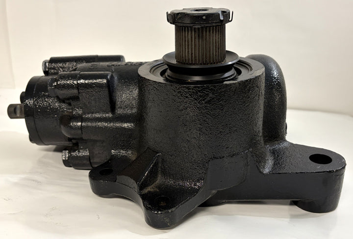 Black cast metal steering gear component with visible mounting points and a cylindrical gear shaft, designed for automotive use, shown against a plain white background.