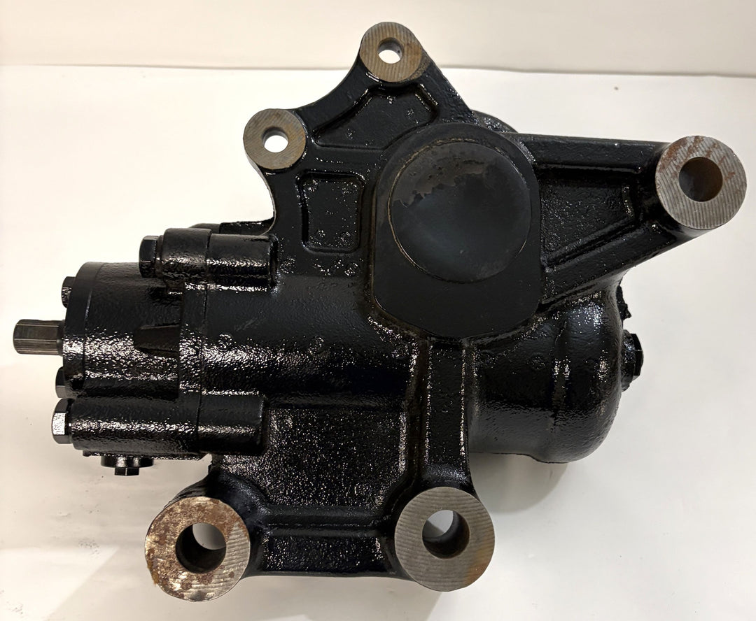 Black cast metal steering gear component by Sheppard, showing mounting points and a cylindrical housing designed for automotive applications on a plain background.