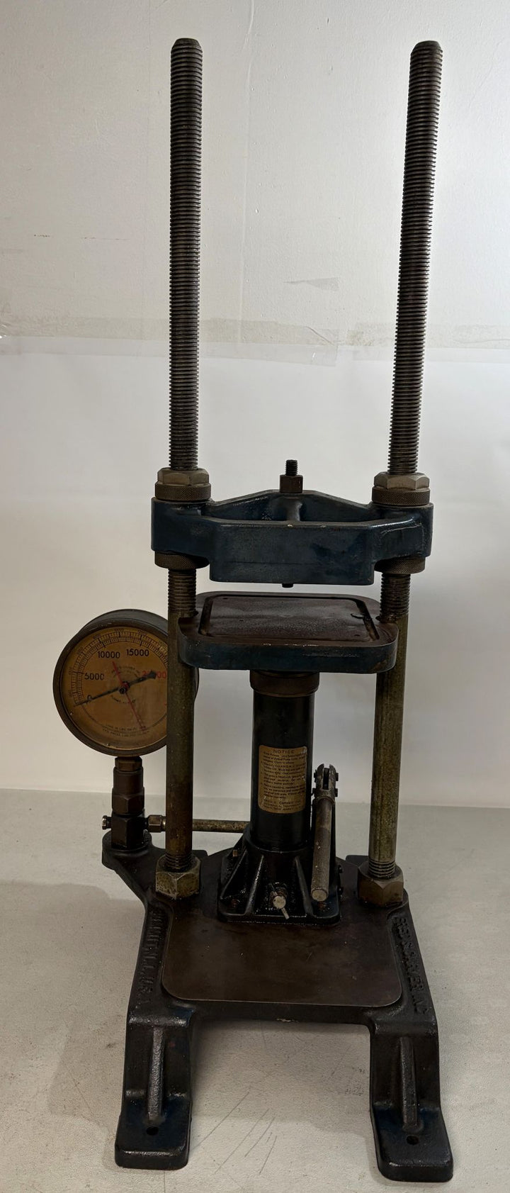 Pre-owned hydraulic bench press with pressure gauge and sturdy metal frame, designed for laboratory or industrial use, crafted by Carver Inc.