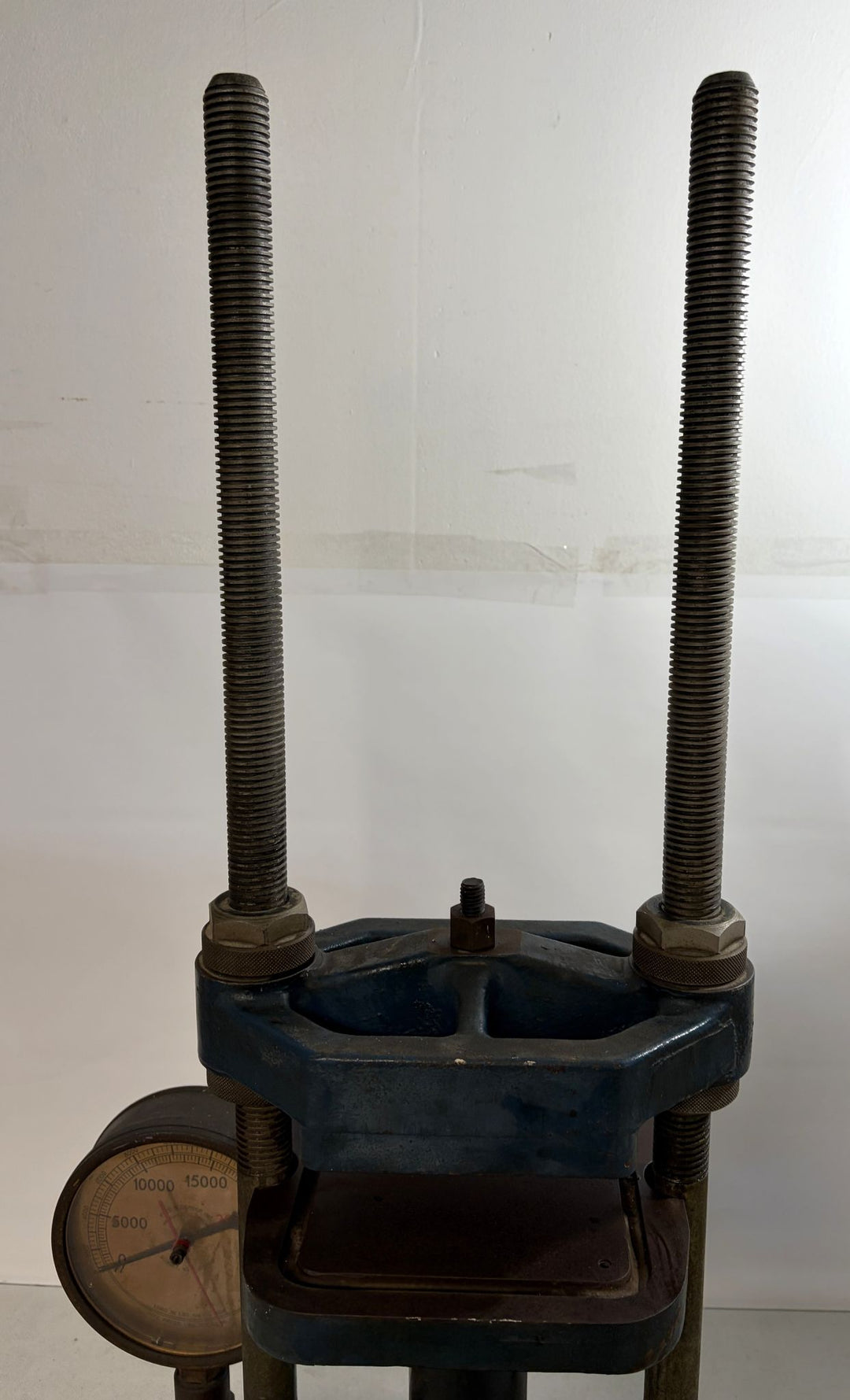 Pre-owned Carver Inc hydraulic press with large threaded rods, pressure gauge, and sturdy metal frame designed for industrial or laboratory use.