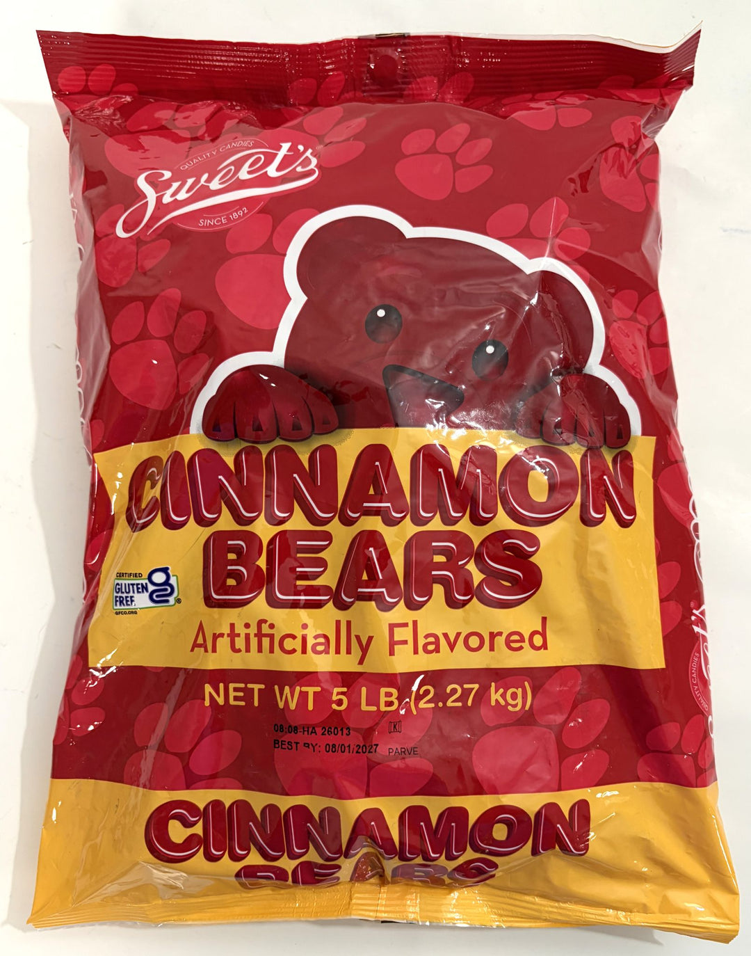Large red and yellow bag of Sweet Candy Company cinnamon bear gummy candy with bear graphic and gluten free label on a white background.