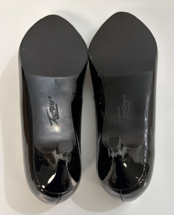 Black patent leather shoes with visible brand logo on a white background