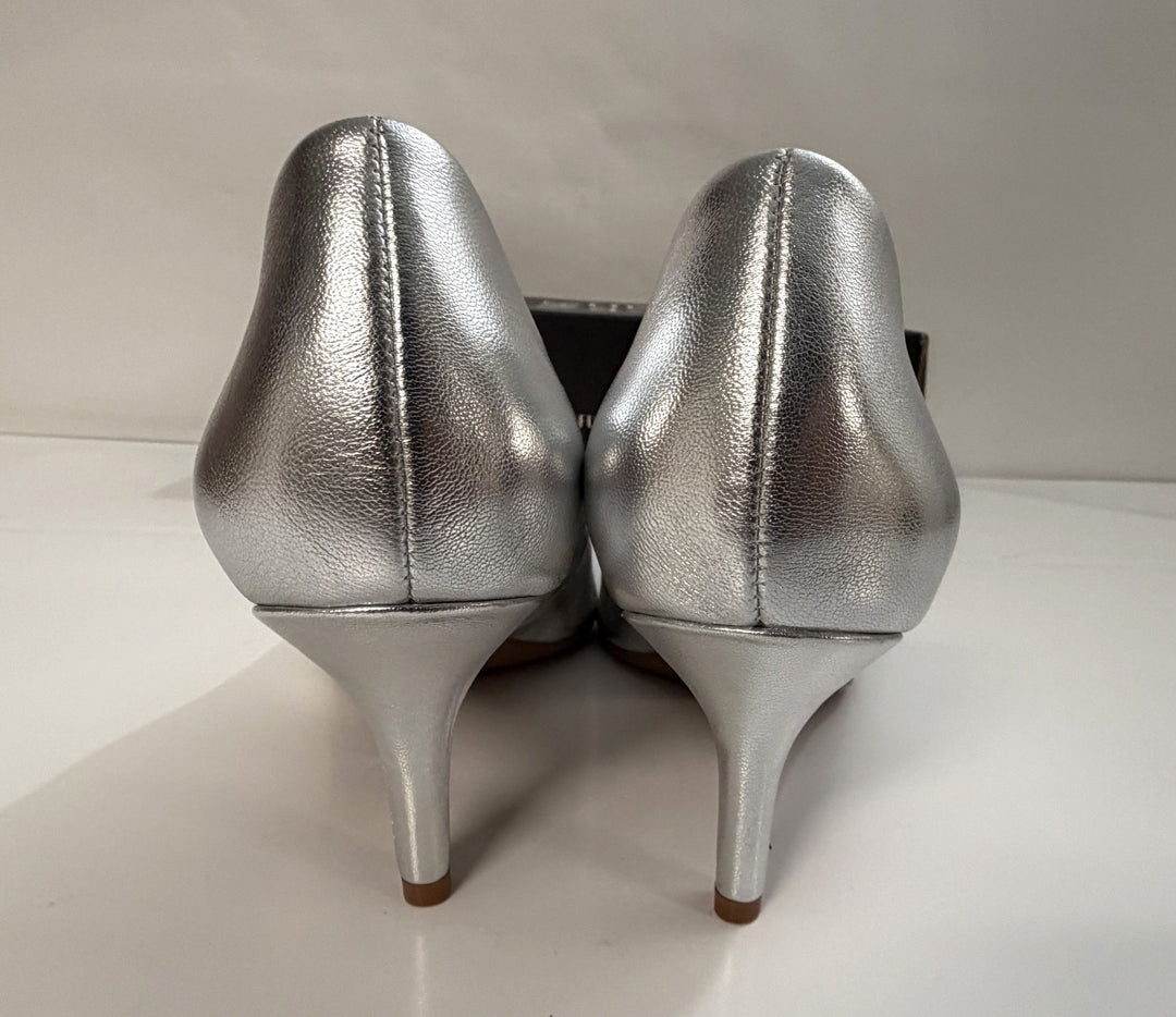 Pair of metallic silver high heel shoes shown from the back on a neutral surface with a subtle shine on the material