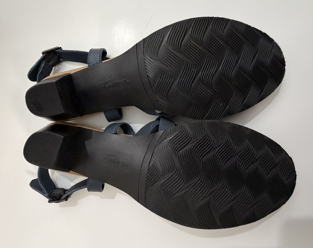 Pair of Trotters navy strappy heeled sandals shown from the rubber soles with textured grip and a low block heel on a white background.