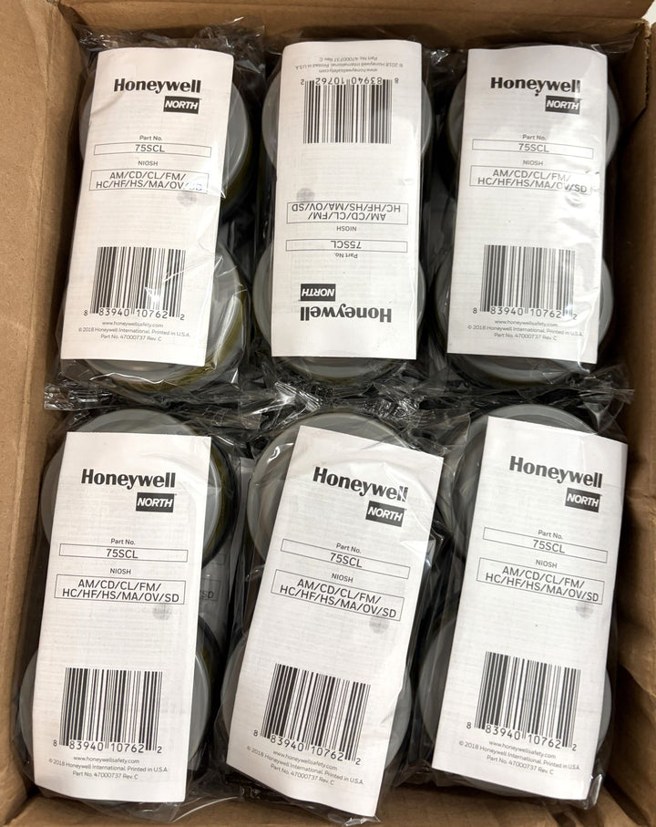 Open cardboard box containing multiple sealed Honeywell North respirator cartridge packs arranged in two rows, featuring white labels with product details and barcodes.